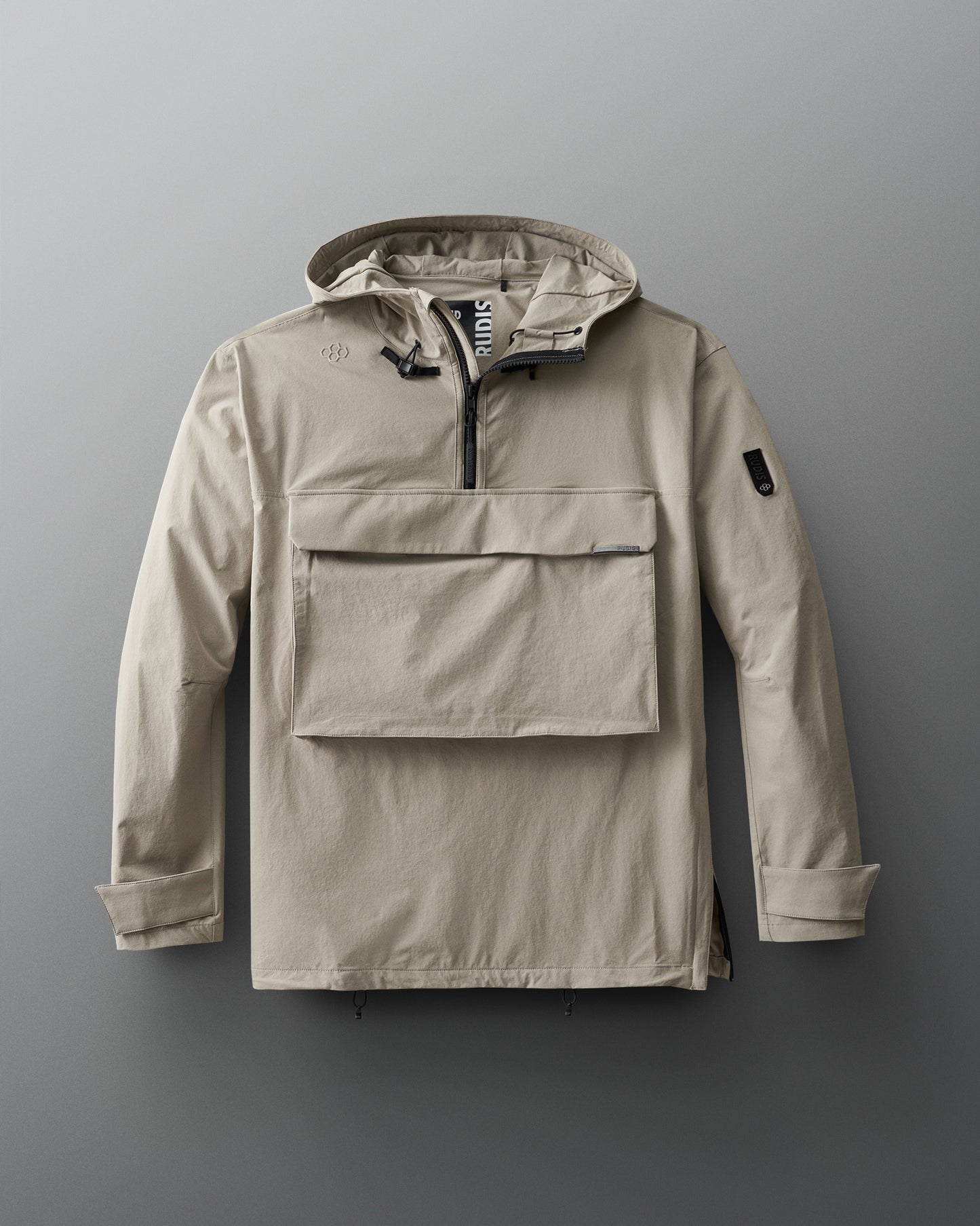 A beige, 1/4 zip jacket with a hood, designed for adults. The jacket features a front gear pocket, adjustable cuffs, hood, and waist, and is displayed on a grey background.