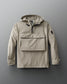 A beige, 1/4 zip jacket with a hood, designed for adults. The jacket features a front gear pocket, adjustable cuffs, hood, and waist, and is displayed on a grey background.
