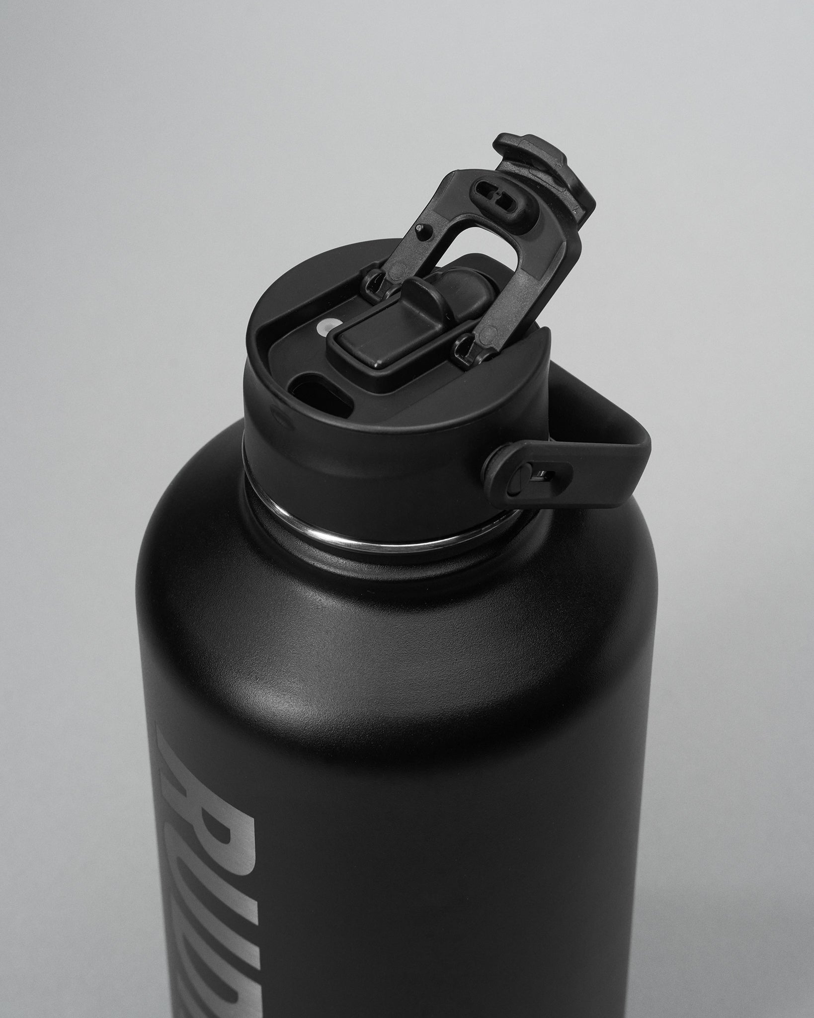 Black water bottle with a screw-on cap on a light gray background