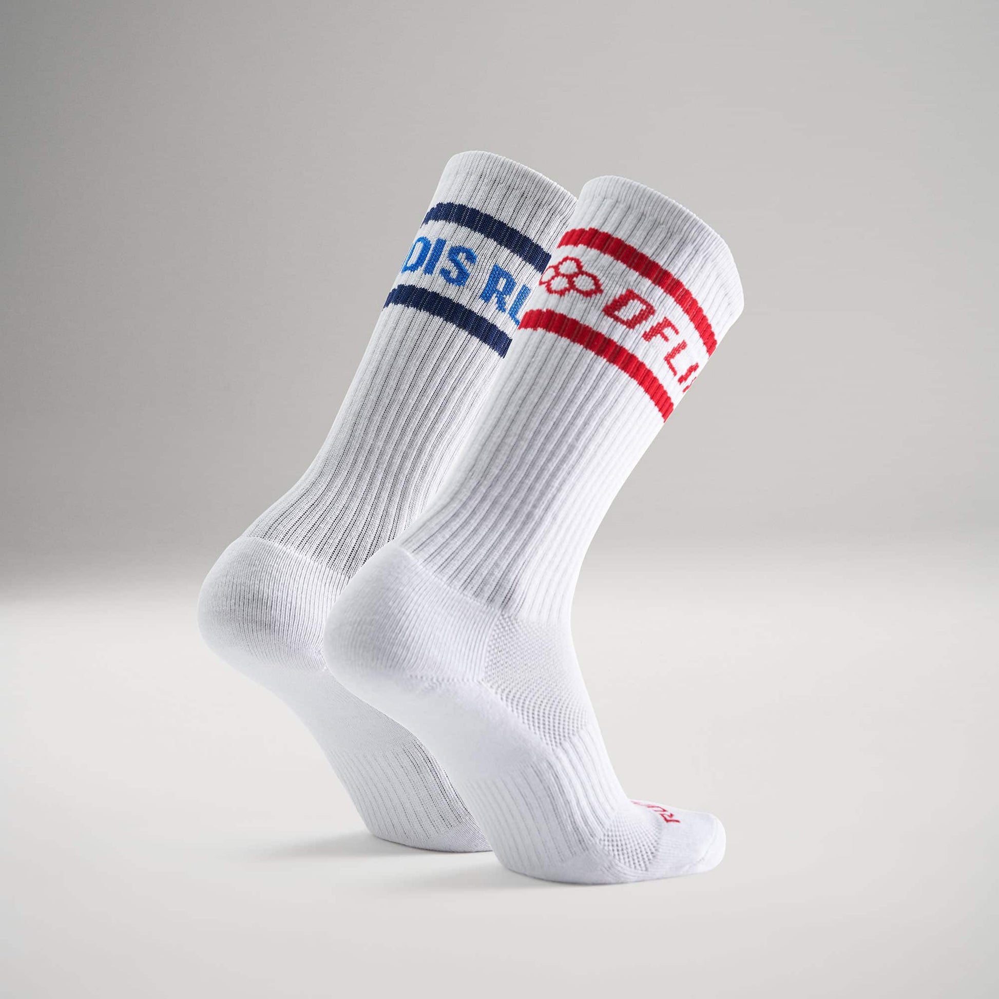 This image features a pair of white athletic socks one adorned with a blue band and the other with a red band each displaying distinct text for branding purposes