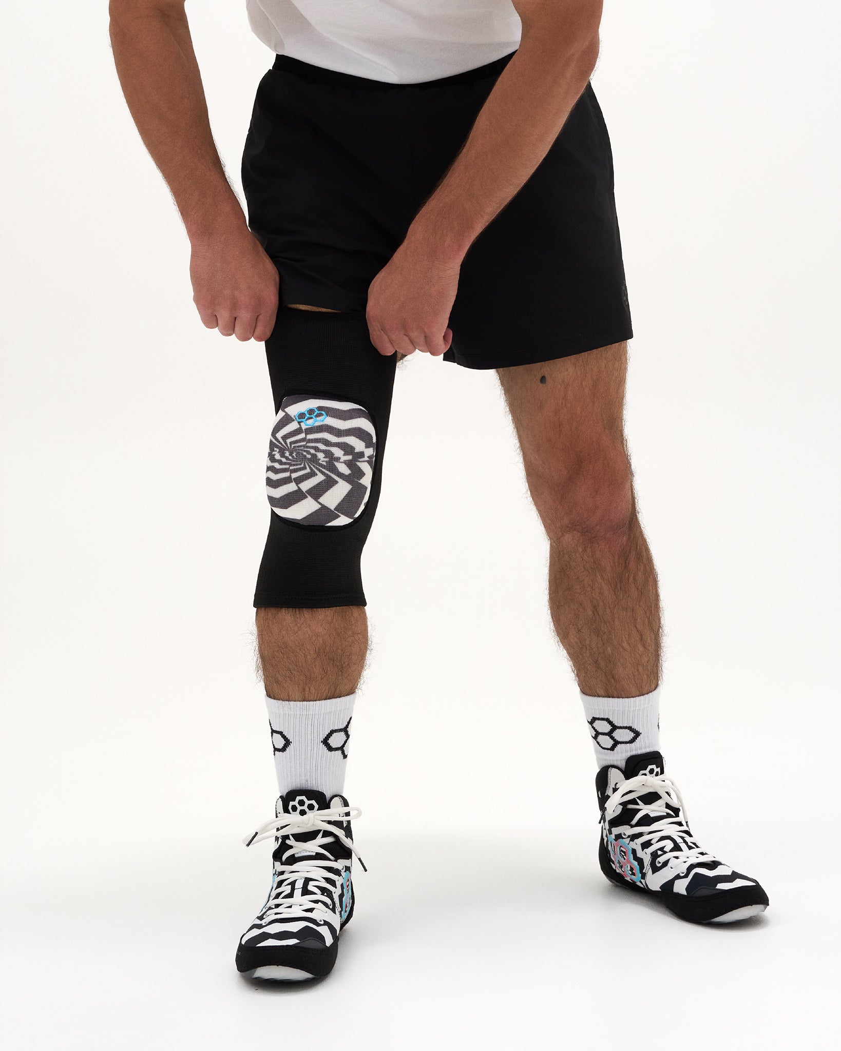 Close-up of RUDIS HPS Cushion Hypnosis Wrestling Knee Pad showing the black sleeve and Hypnosis graphic cushion