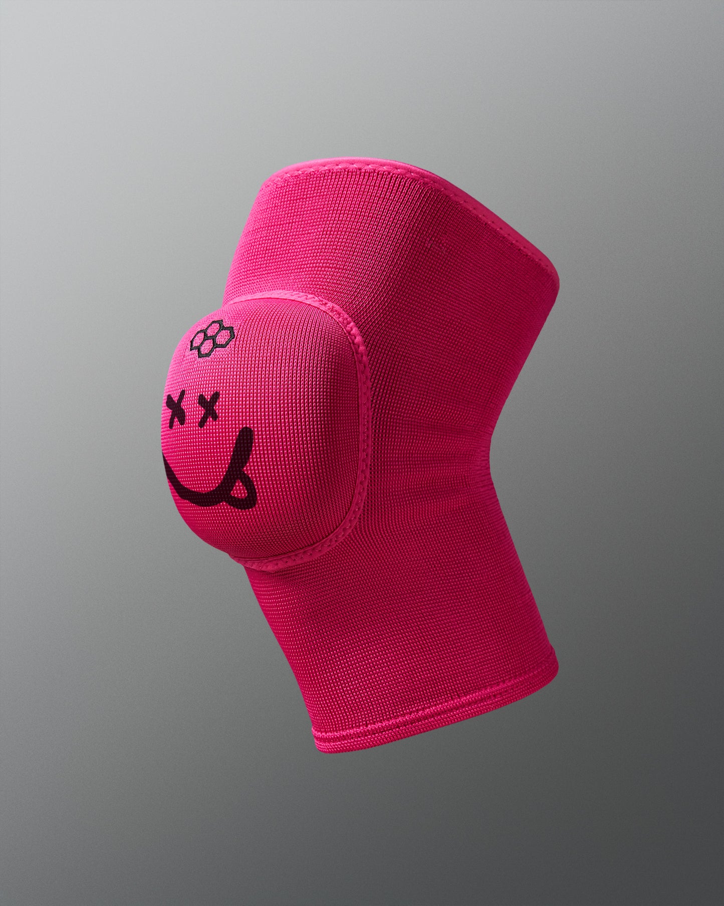 Pink knee pad with a smiley face design on a gray background