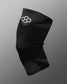 A black athletic knee sleeve with a white Quadhex logo on the upper section, displayed against a neutral gray gradient background.