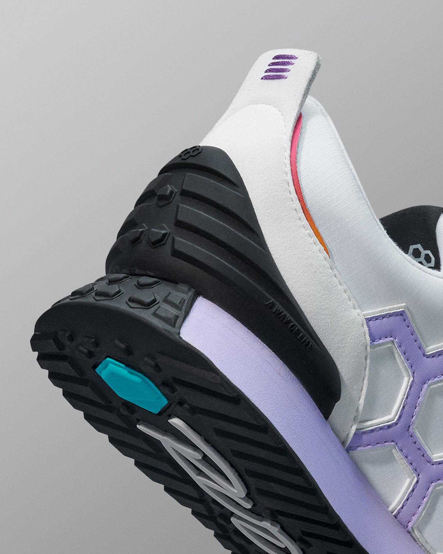 Close-up of a sneaker with a focus on the sole and side details against a gray background