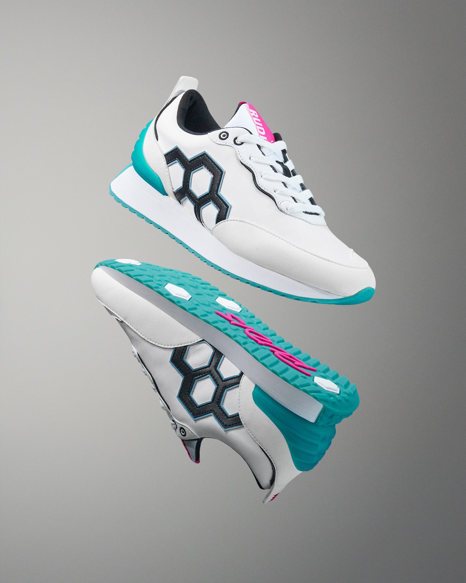 White sneakers with teal soles and pink accents on a gray background