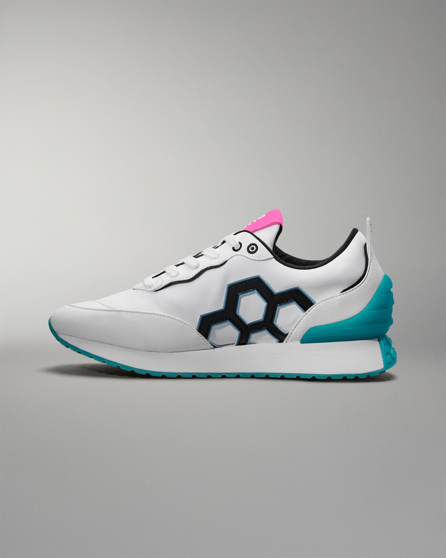 White sneaker with blue sole and pink accent on a gray background