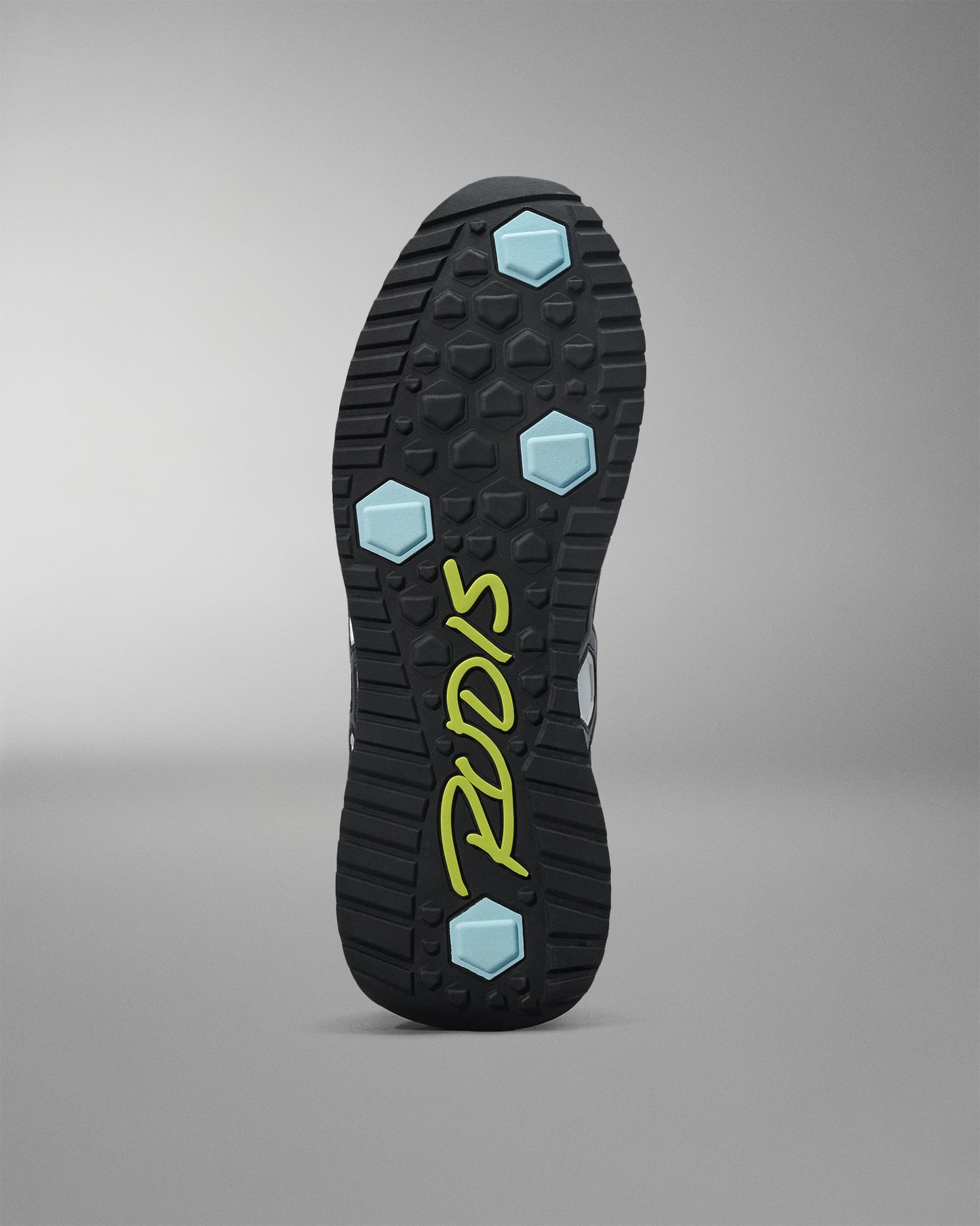 Close-up of a shoe sole with brand logo on a gray background