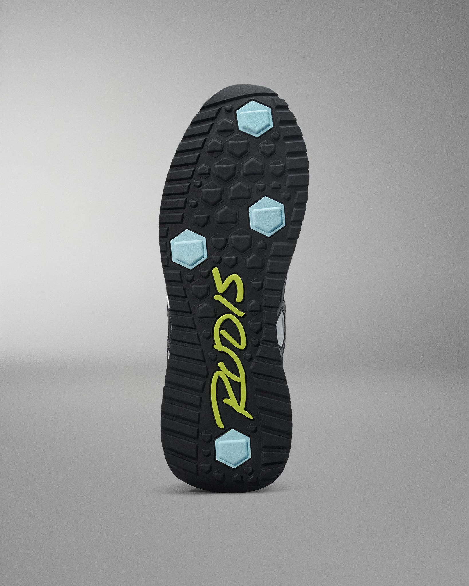 Close-up of a shoe sole with brand logo on a gray background