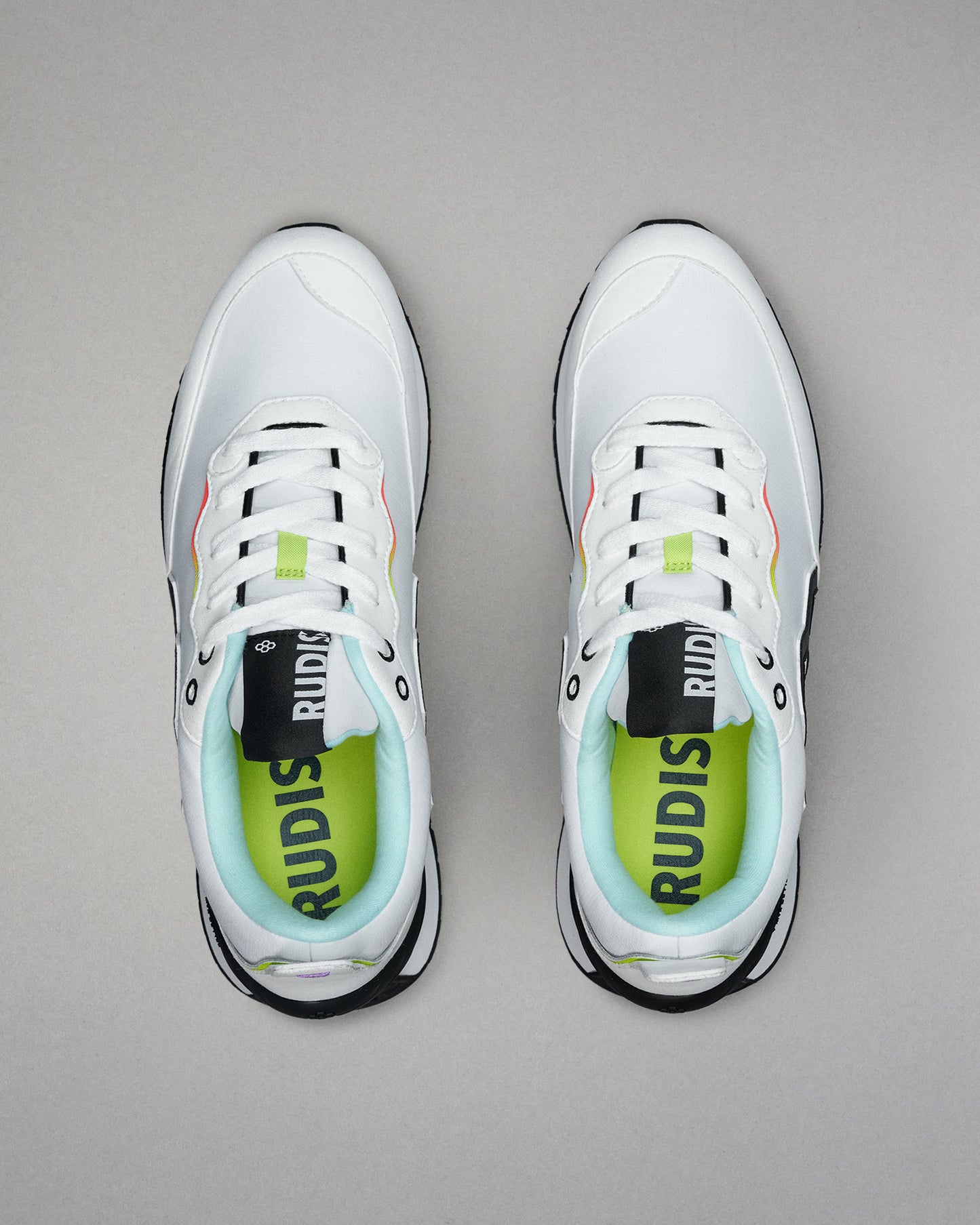 White sneakers with black and green accents on a gray background