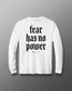 White long-sleeve shirt with 'fear has no power' text on a gray background