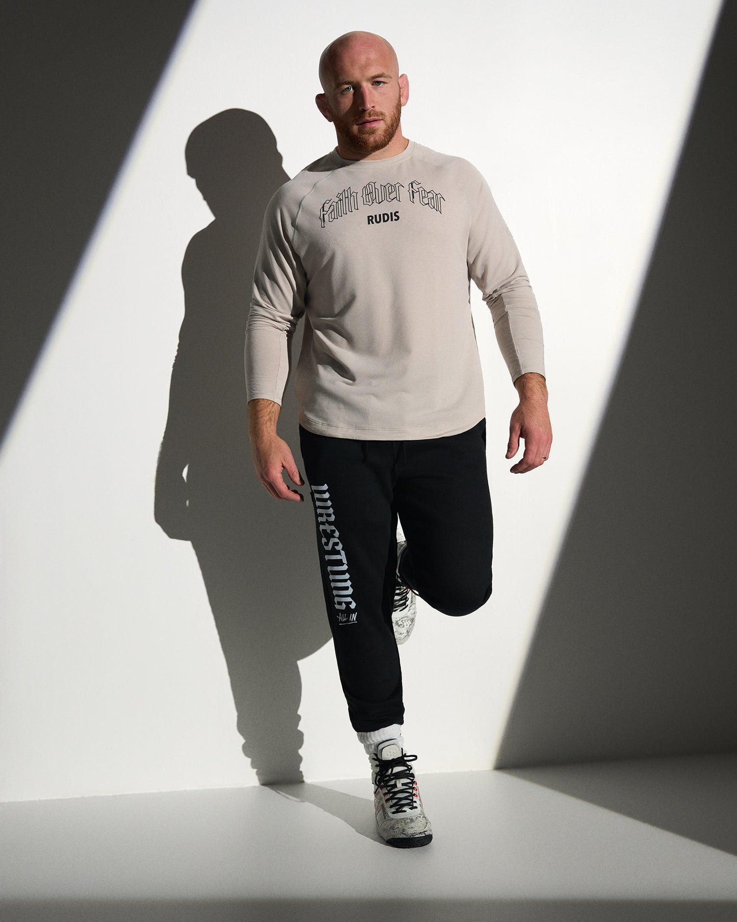 RUDIS Faith Over Fear Tech Thermal in Bone styled with black Gothic Wrestling Titan Heavyweight Joggers, featuring breathable performance fabric, gothic-inspired graphics, and a versatile athletic fit.