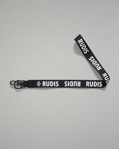 Black RUDIS Wordmark lanyard with repeating white RUDIS logos, woven polyester strap, metal key clip, and key ring for carrying keys, badges, or accessories.