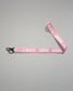Light pink RUDIS Wordmark lanyard with repeating white RUDIS logos, woven polyester strap, metal key clip, and key ring for carrying keys, badges, or accessories.