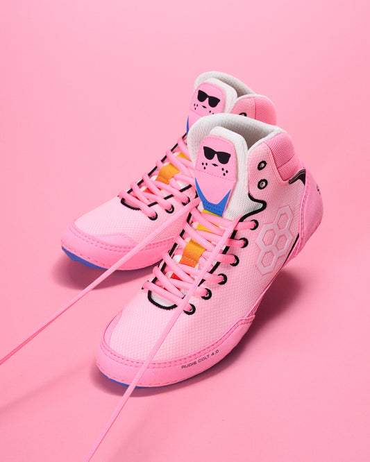 Pink wrestling shoes with energizer bunny character design on a pink background