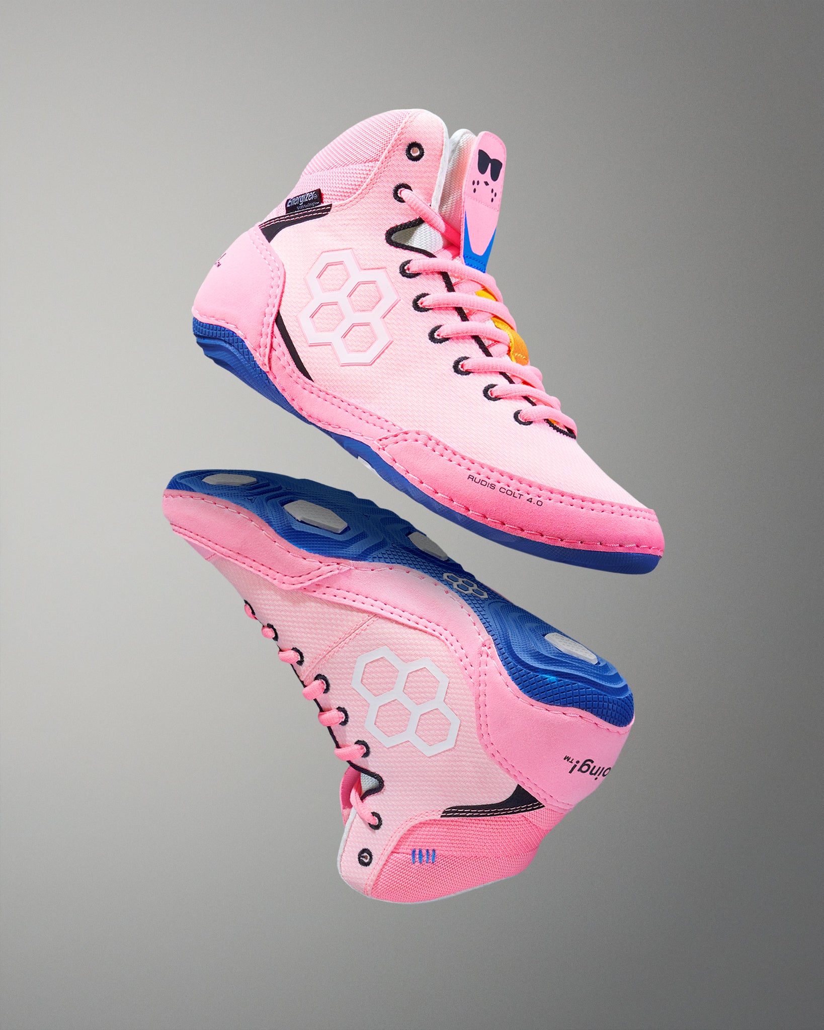 Pink wrestling shoes with blue soles on a gray background