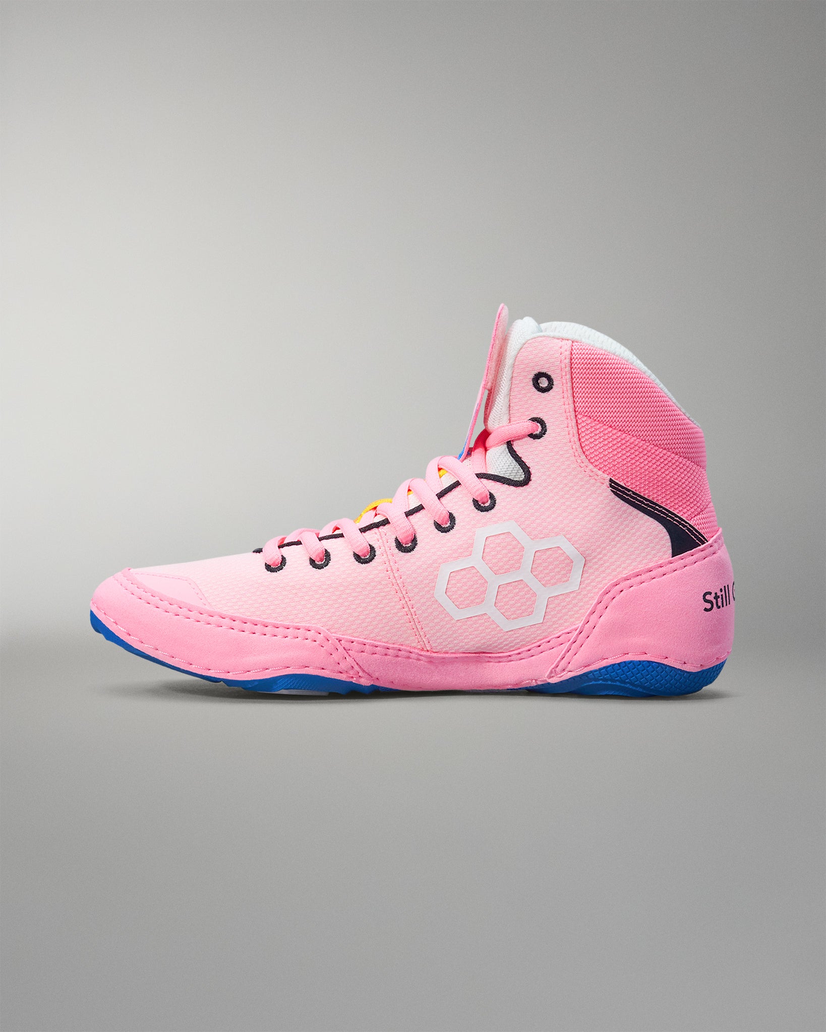 Pink wrestling shoes with blue sole on a gray background