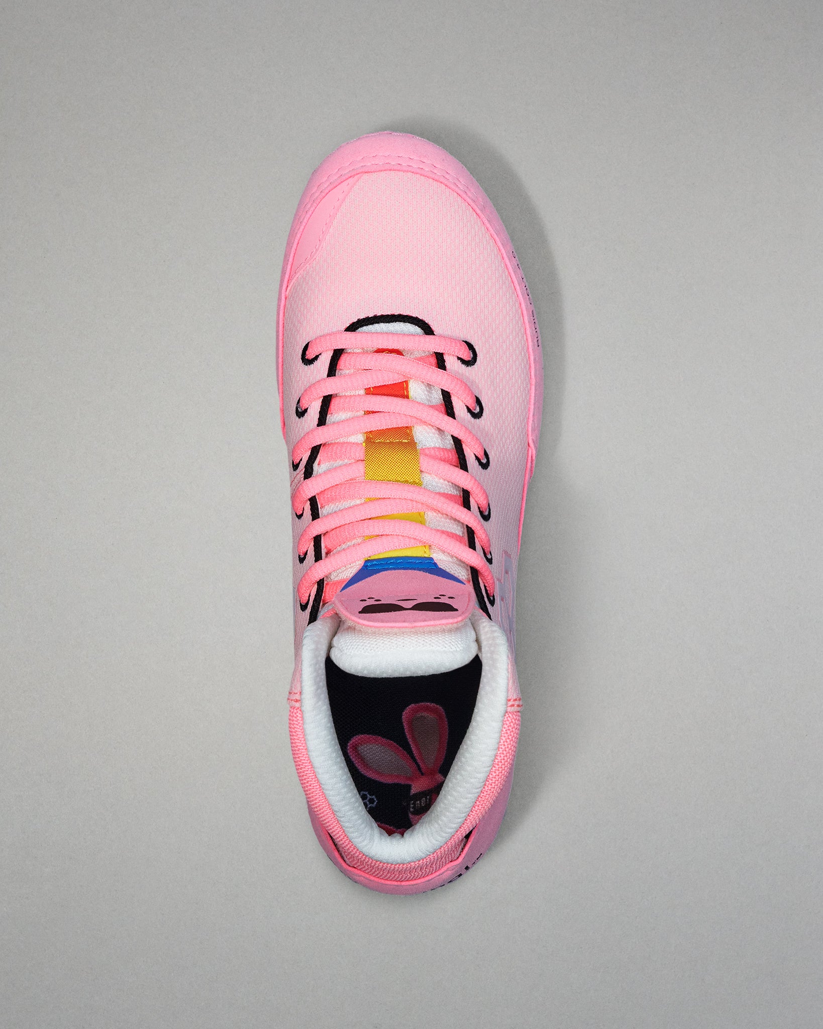 Pink wrestling shoe with colorful accents on a gray background