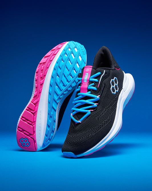 Black and pink running shoes with blue accents on a blue background