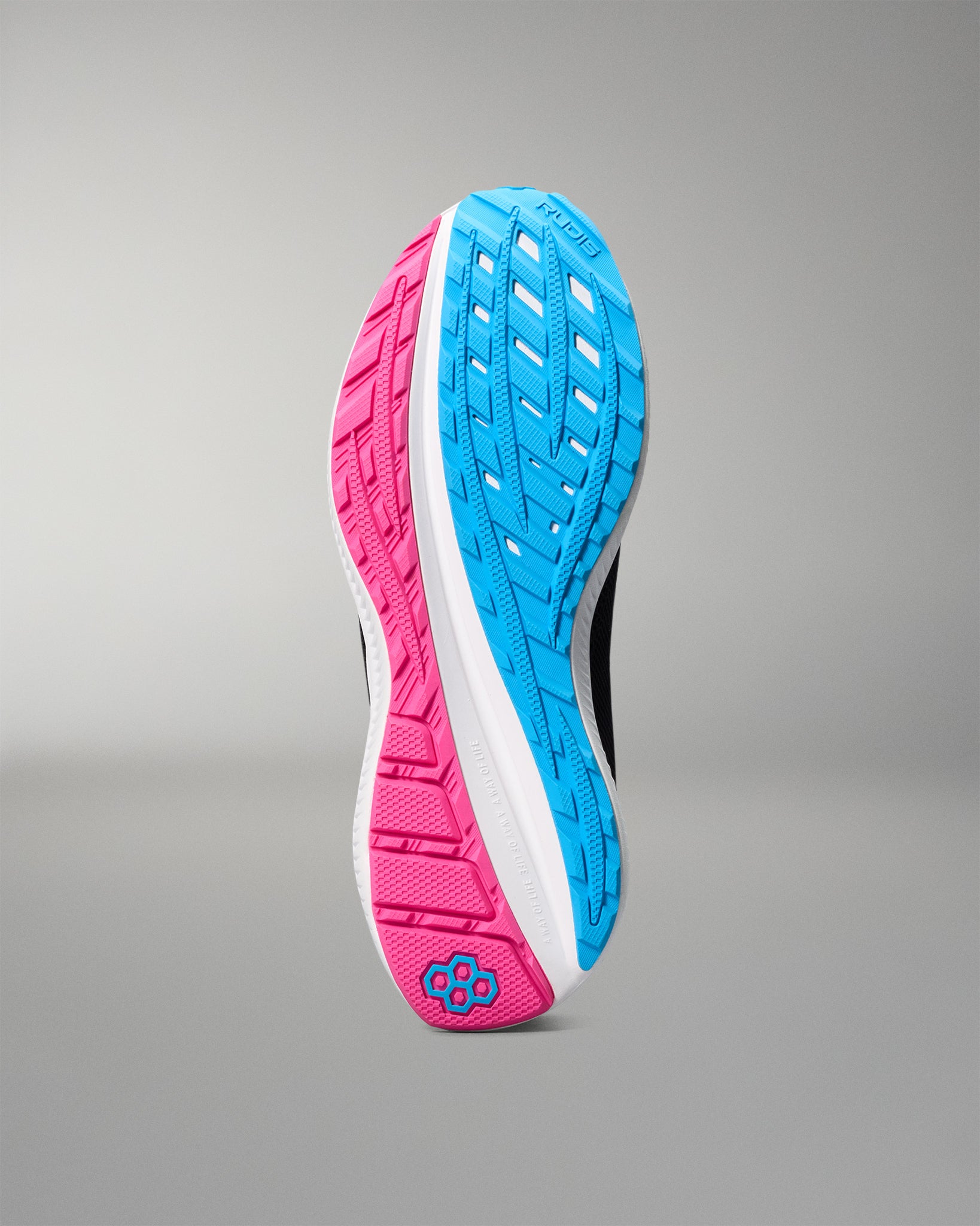 Close-up of a running shoe sole with pink and blue tread pattern on a gray background
