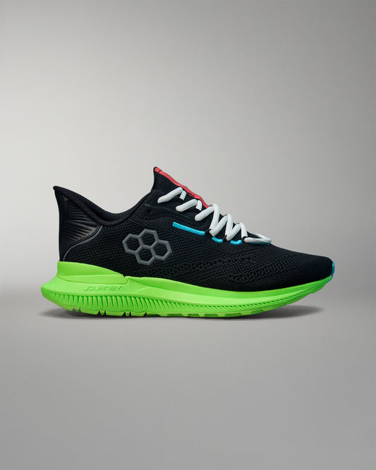 Black running shoe with green sole on a gray background
