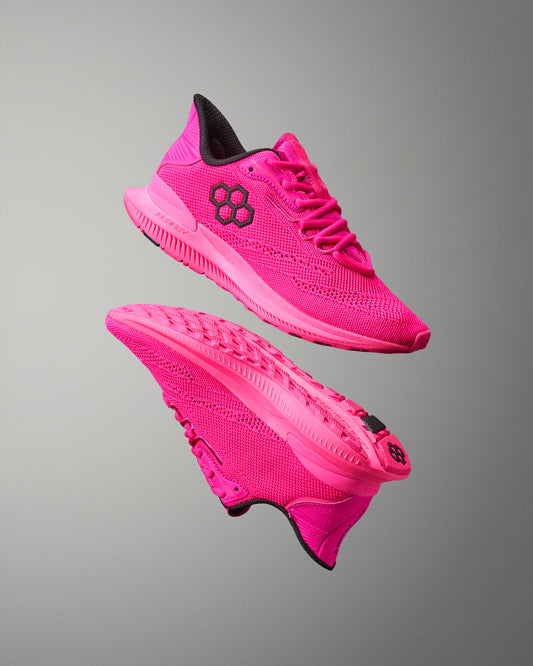 Pink running shoes with black accents on a gray background