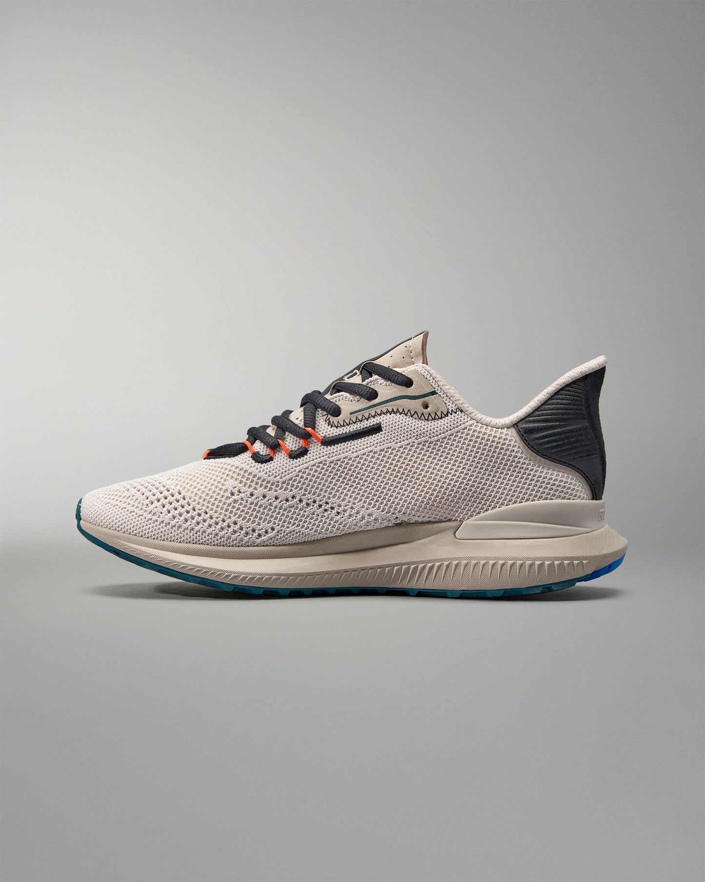 White running shoe with black and blue accents on a gray background