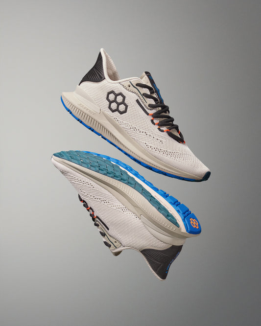 White running shoes with blue soles on a gray background