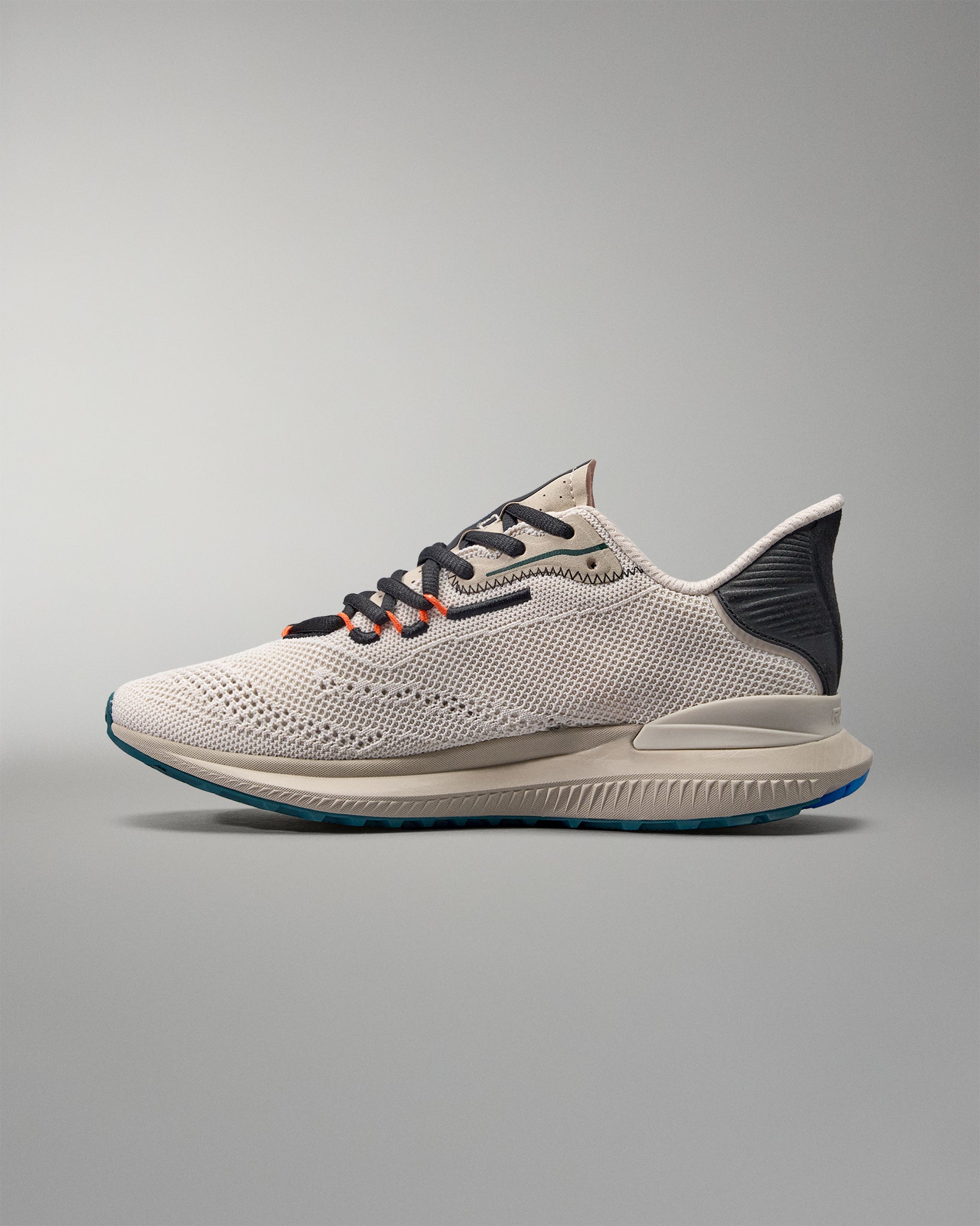 White running shoe with black and blue accents on a gray background