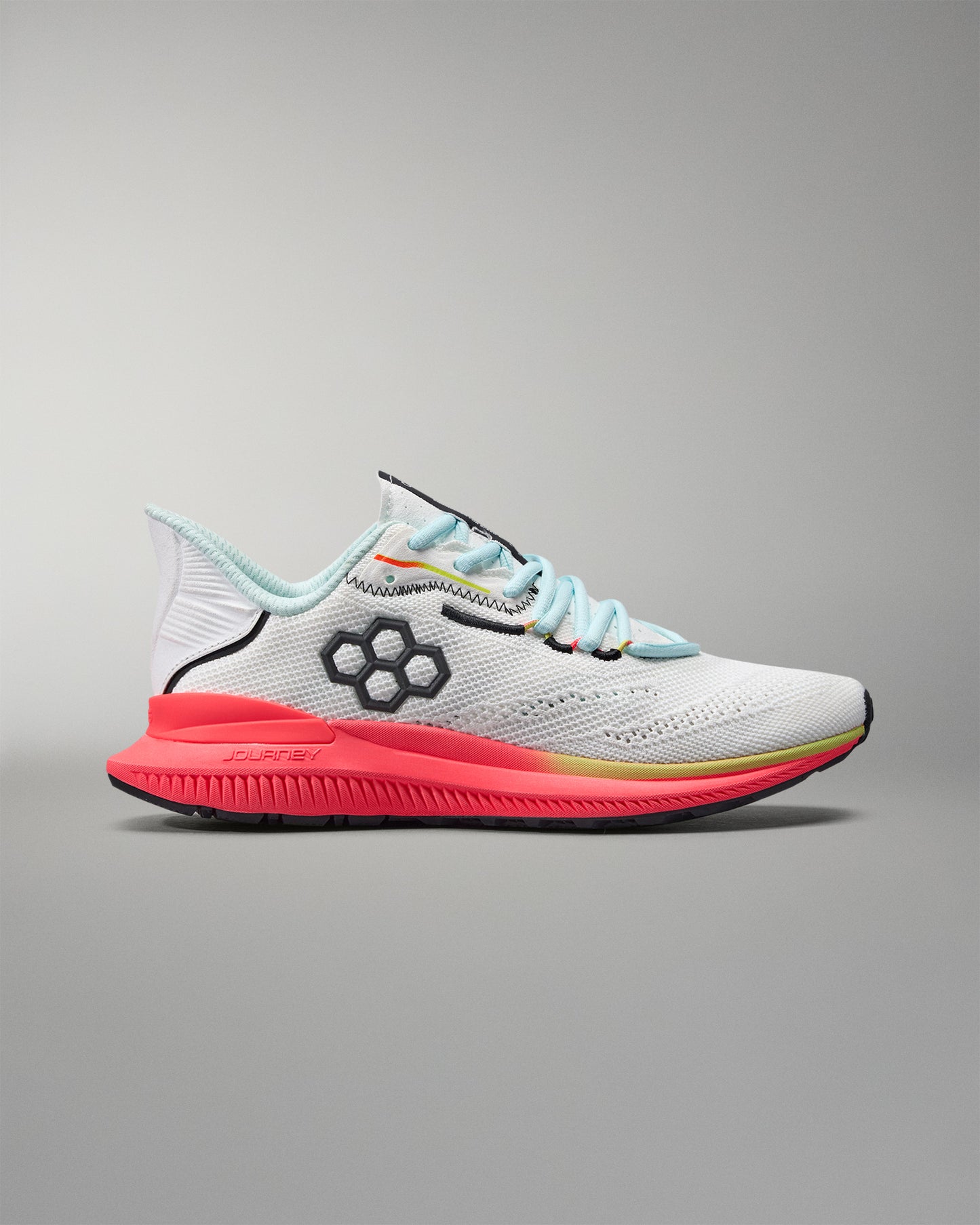 White running shoe with colorful sole on a gray background