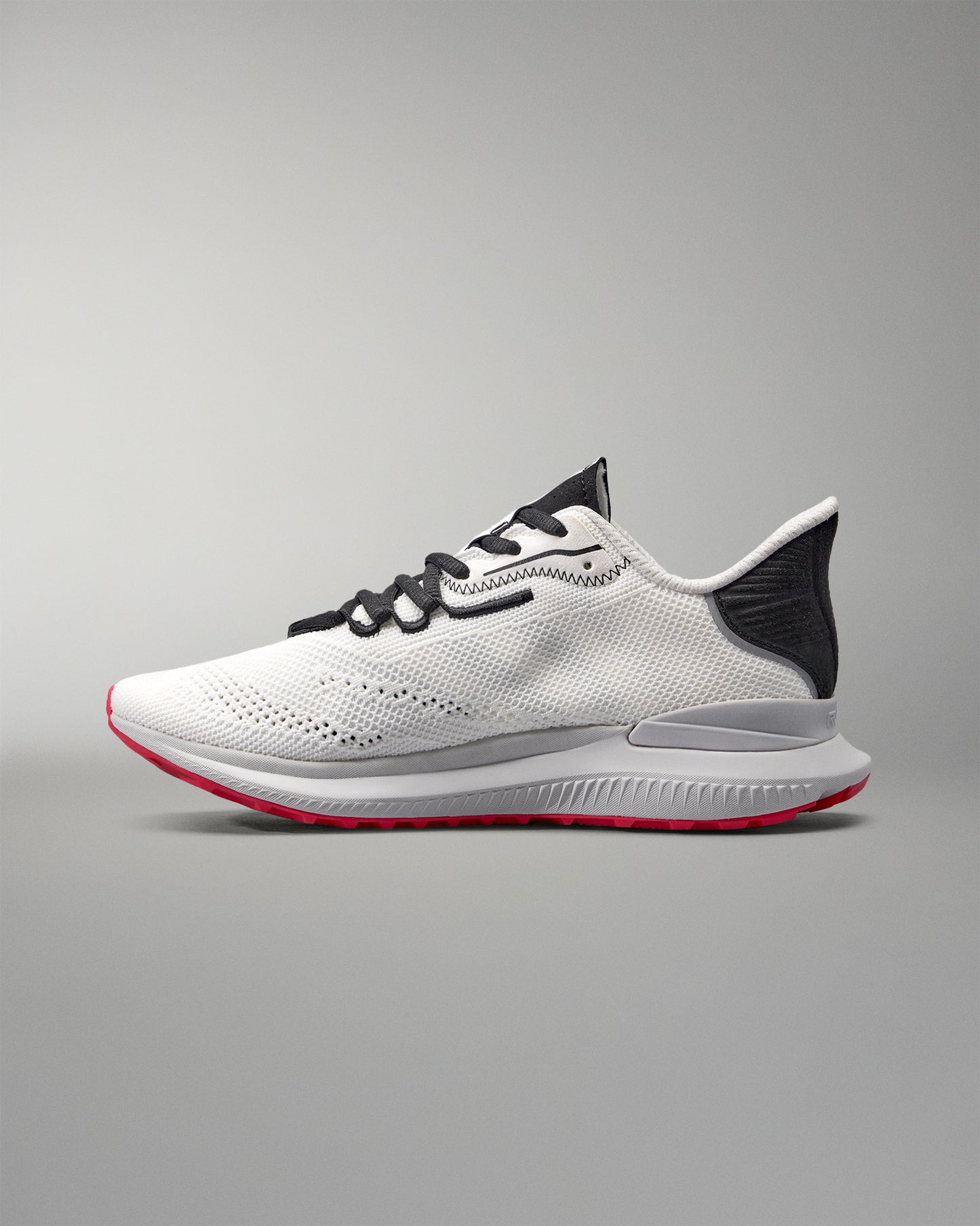 White running shoe with black and red accents on a gray background
