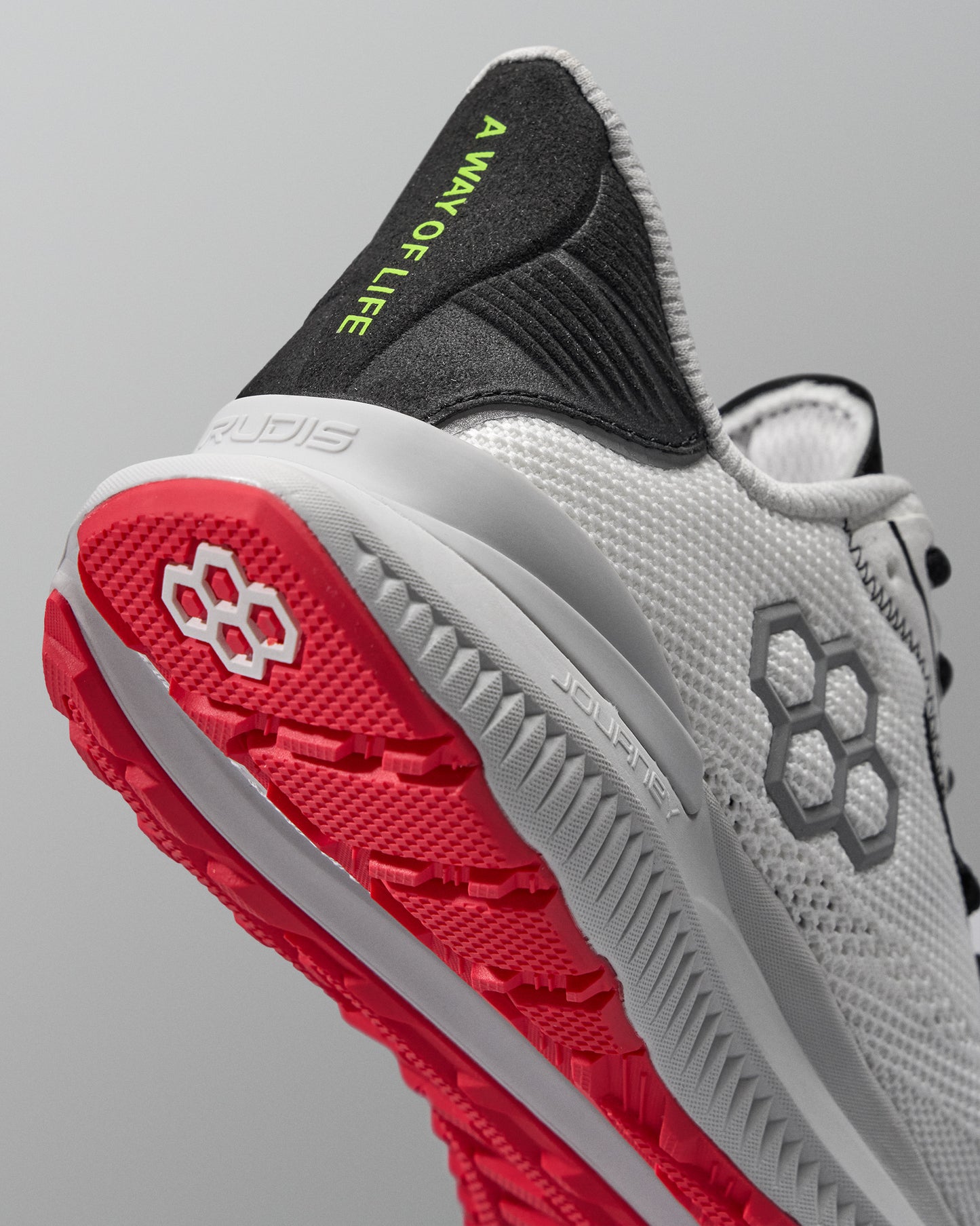 Gray and red running shoe with visible brand logos on a gray background