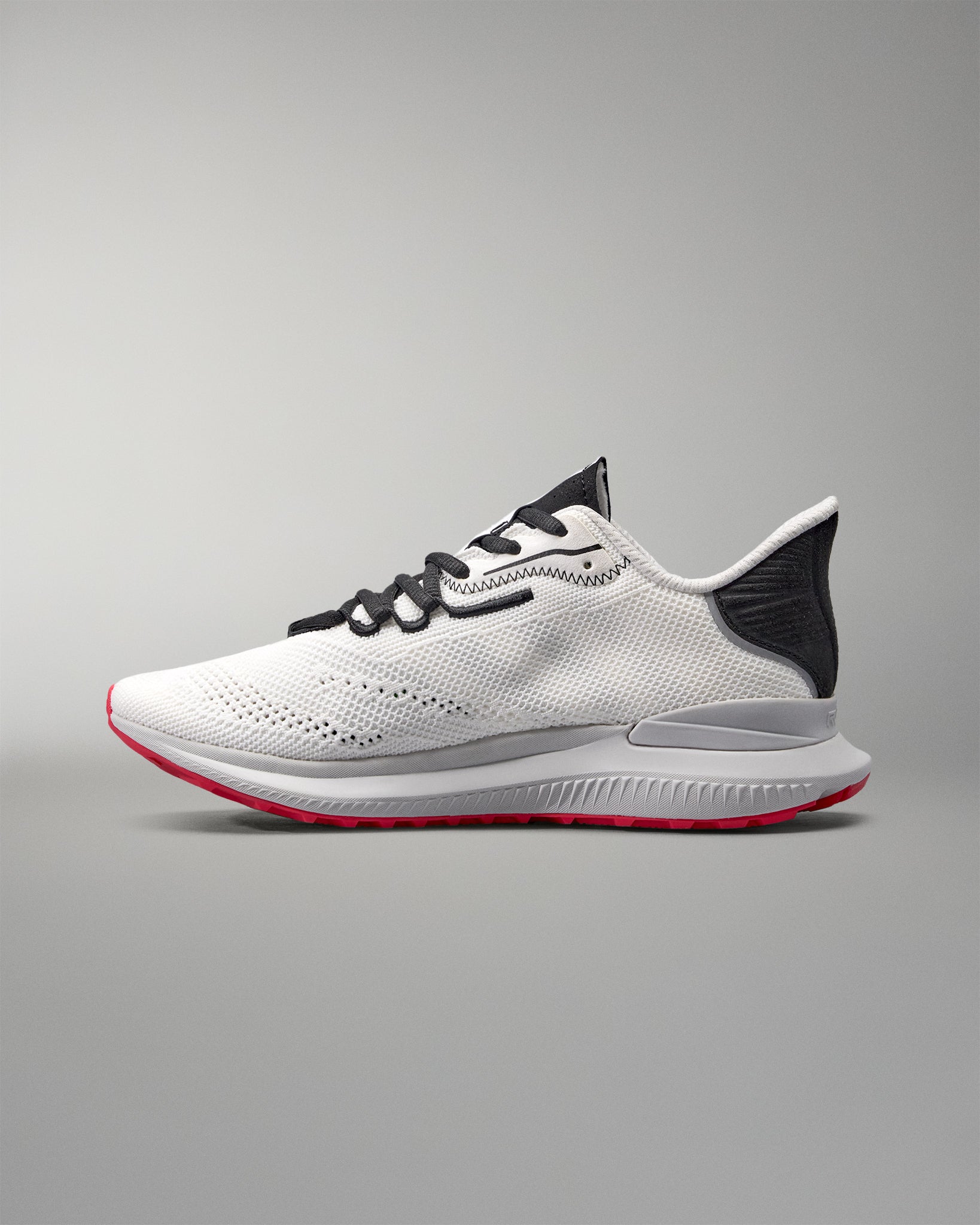 White running shoe with black and red accents on a gray background