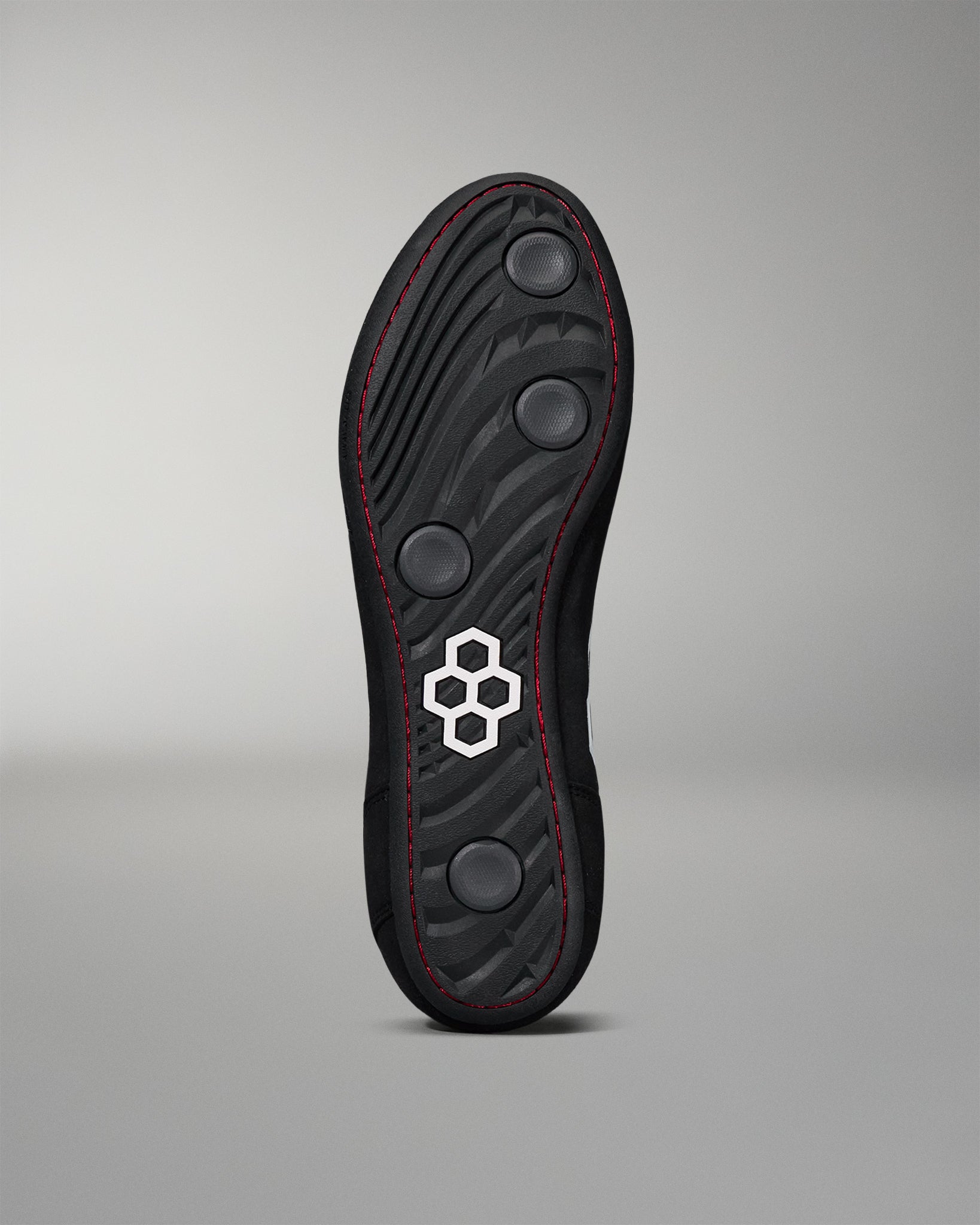 Outsole image of the RUDIS international wrestling shoe - black/white on a grey background. 