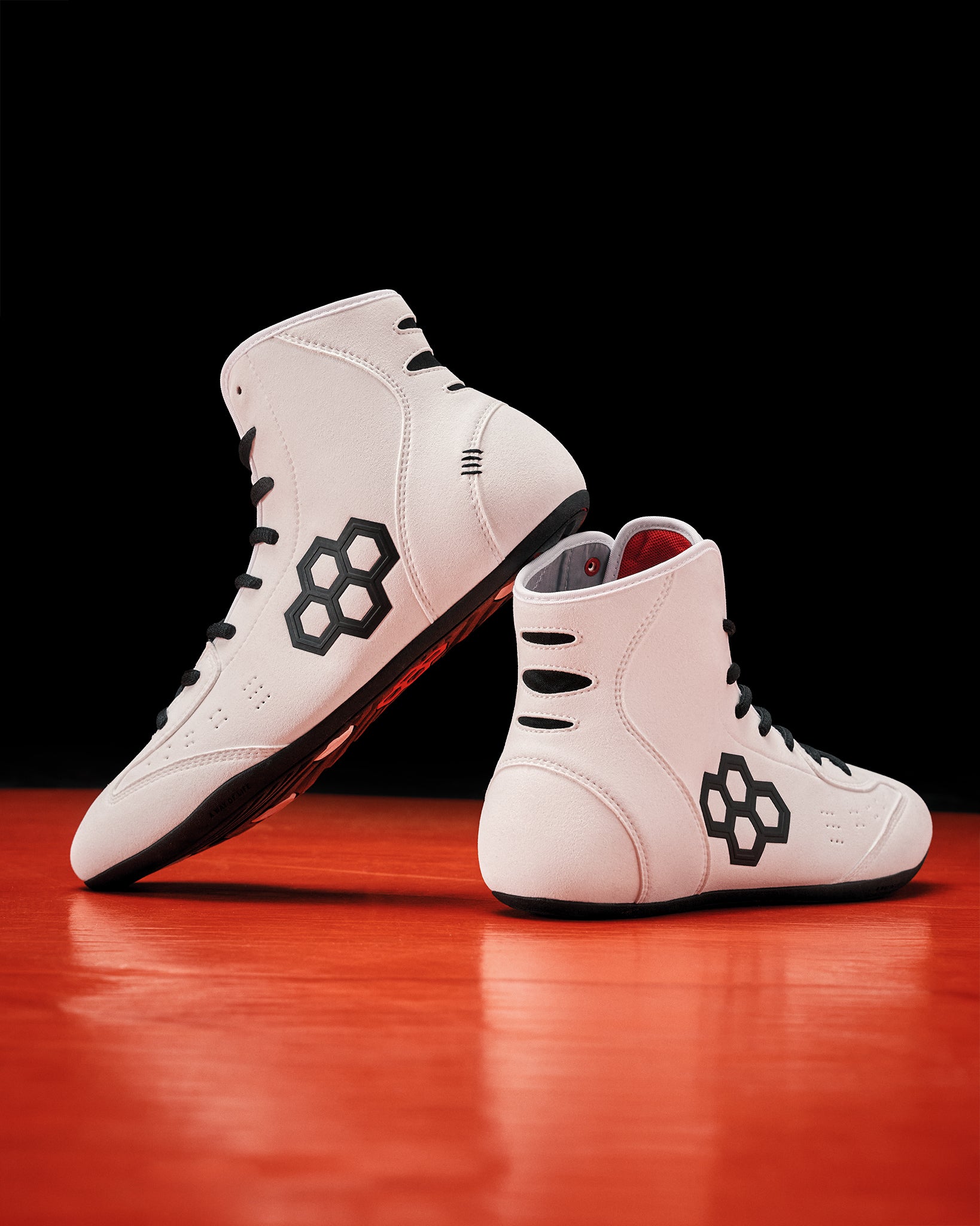 White wrestling shoes on red and black background