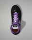 Black shoe with purple laces on a gray background