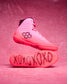 Pink wrestling shoes with black text and logo on a pink background