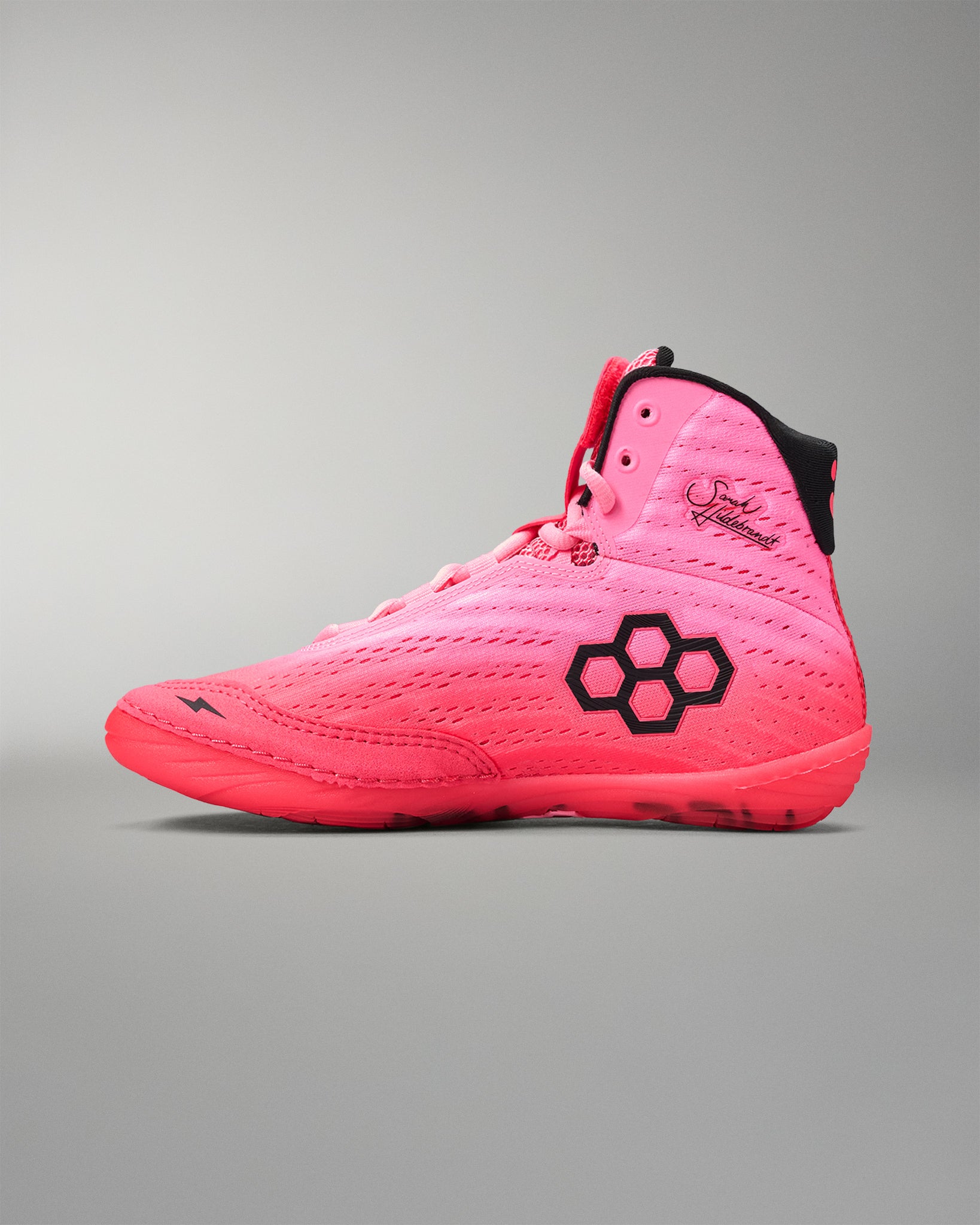 Pink wrestling shoe with a black logo on a gray background