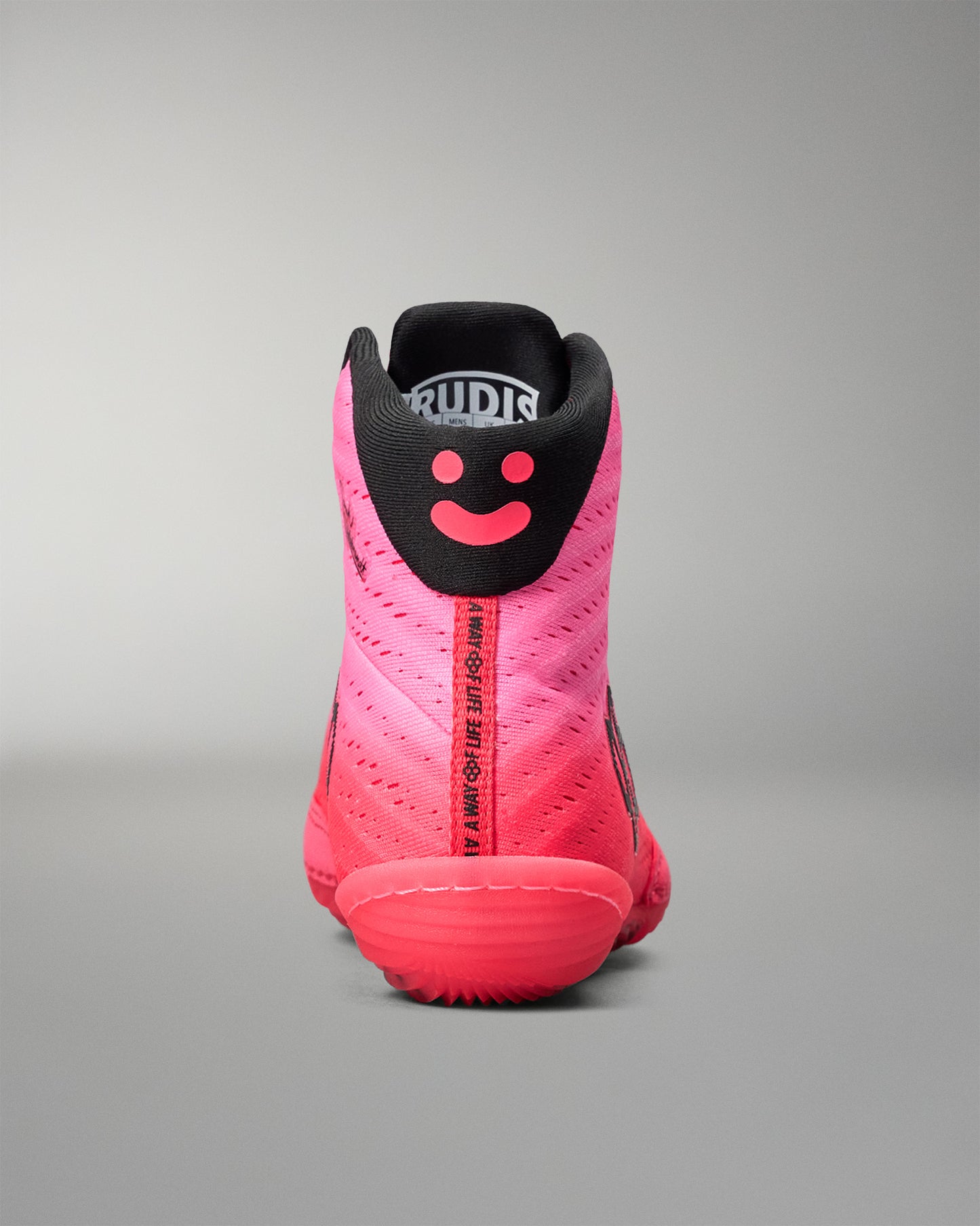 Pink and black wrestling shoe with a smiley face design on a gray background