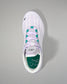 White sneaker with green accents on a gray background