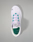 White sneaker with green accents on a gray background