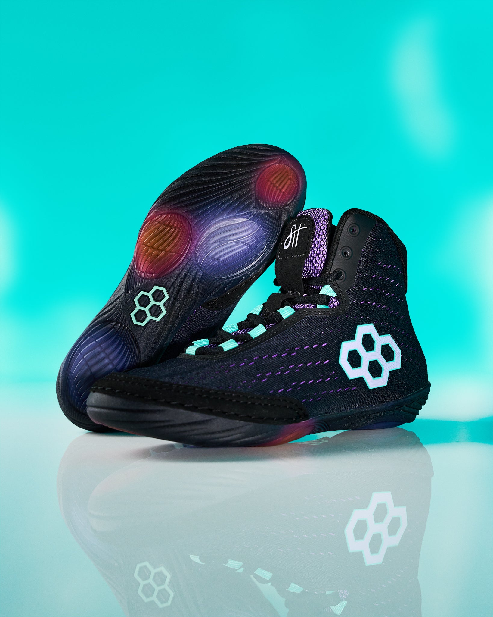 Black high-top sneakers with colorful sole on a reflective surface and teal background