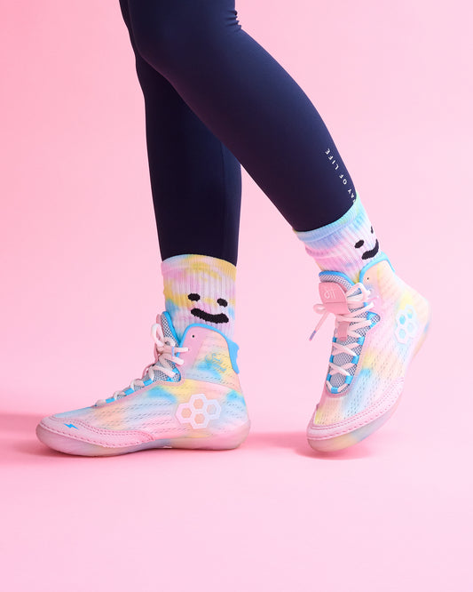 Colorful Wrestling shoes with smiley face design on a pink background