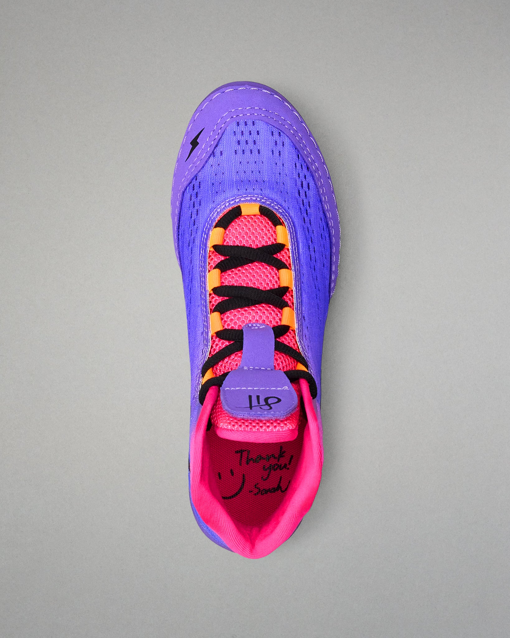 Purple and pink wrestling shoe with black text on a gray background