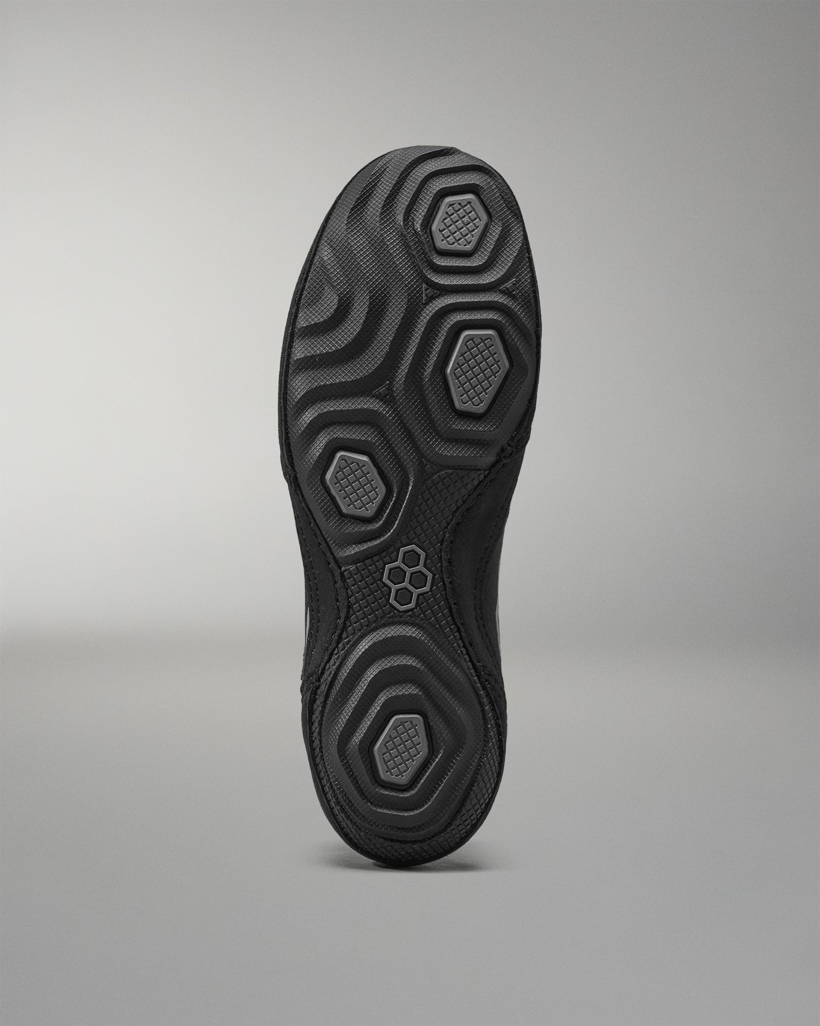 Black Wrestling shoe sole with textured pattern on a gray background