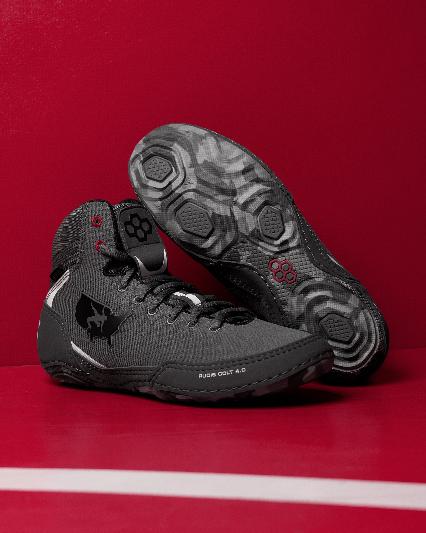 Black wrestling shoes on a red background