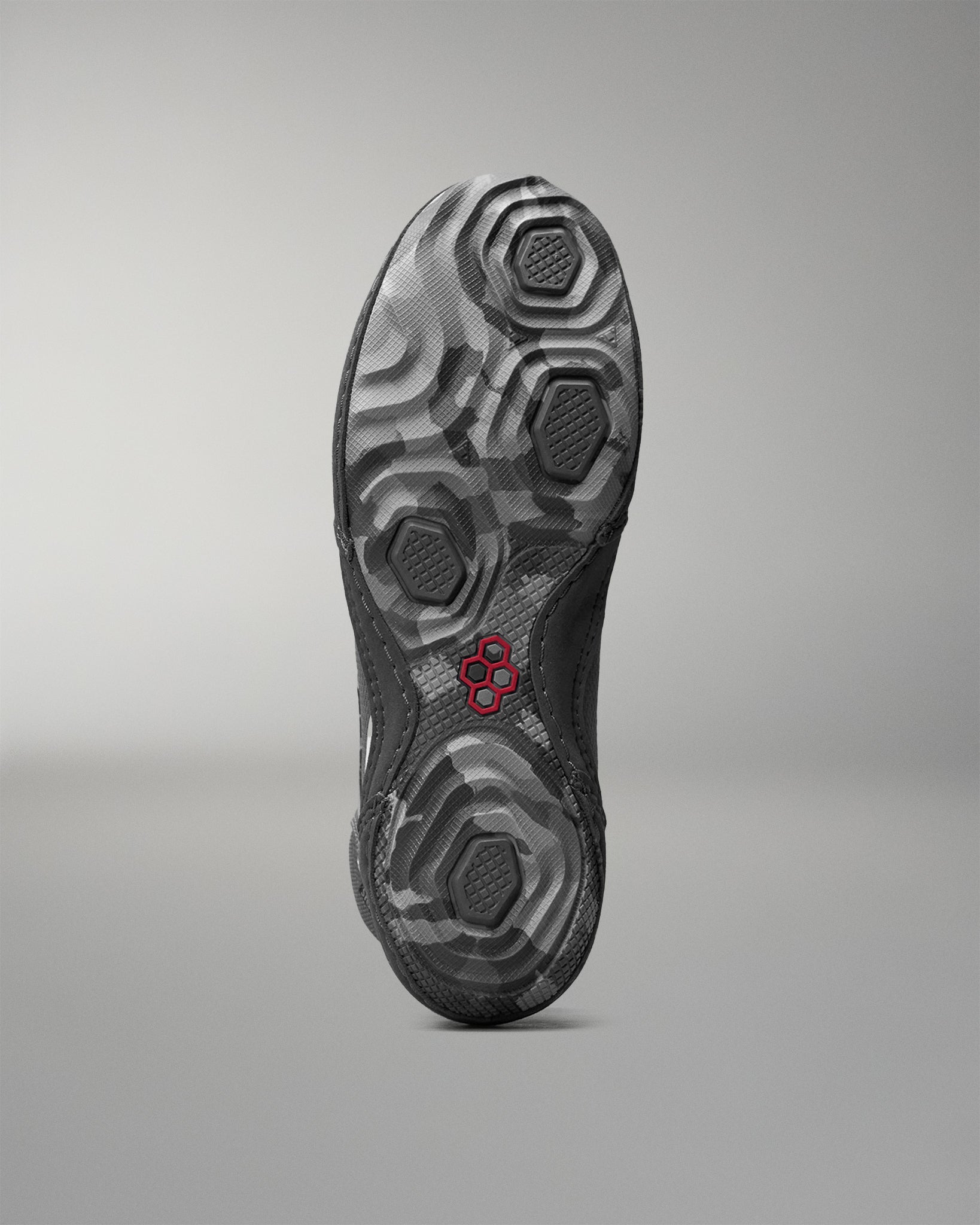 Close-up of a wrestling shoe sole with a textured pattern on a gray background
