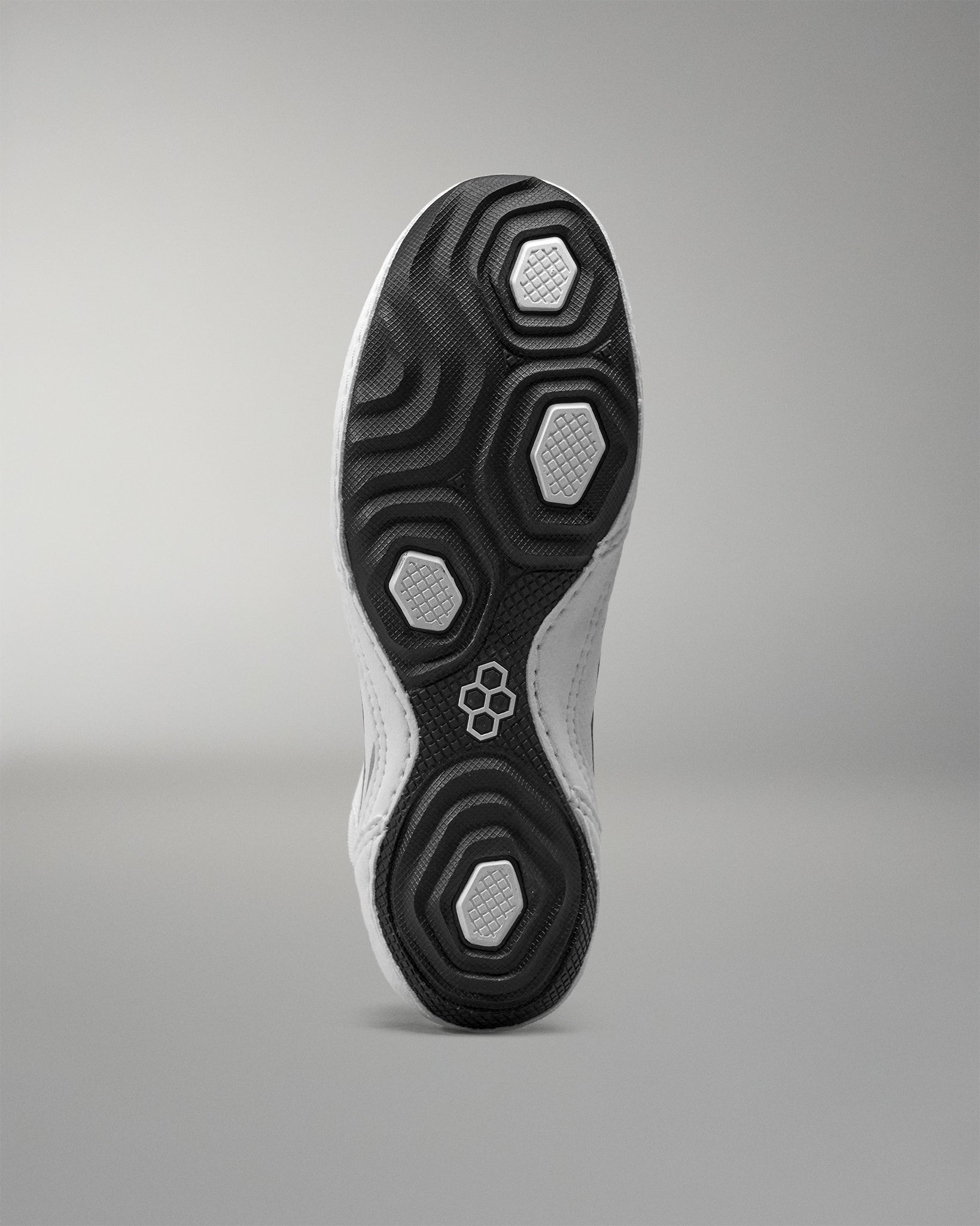 Close-up of a Wrestling shoe sole with a geometric pattern on a gray background