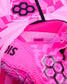 Close-up of a pink RUDIS wrestling shoe showcasing the textured upper, signature honeycomb logo, heel branding, and vibrant pink design against a matching geometric pink background.