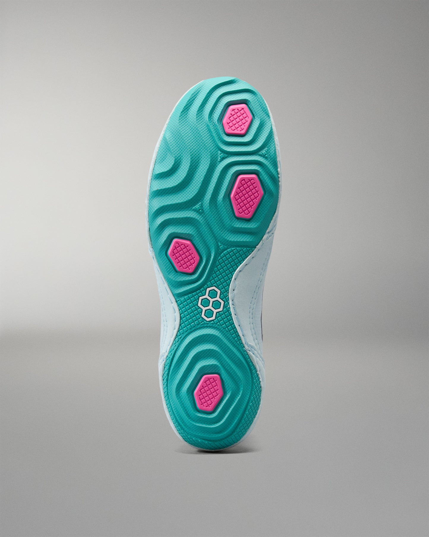 Close-up of a shoe sole with green and pink design on a gray background
