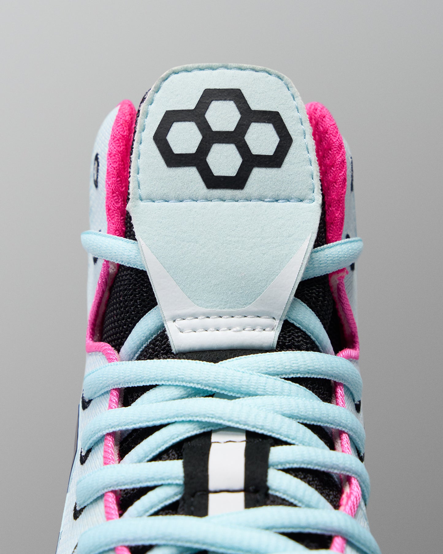Close-up of a sneaker with a distinctive logo on a gray background